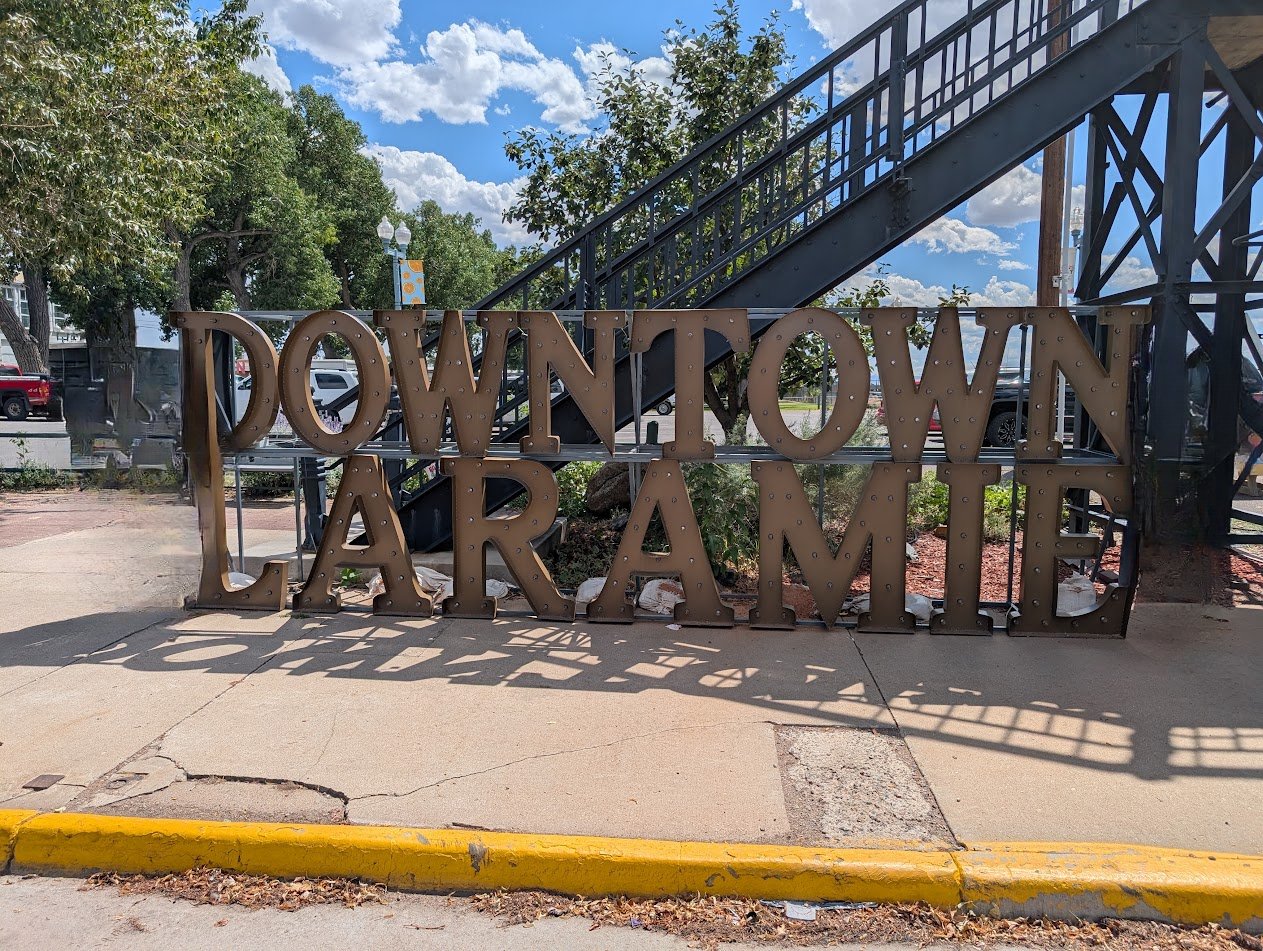 The “Downtown Laramie” sign on a sidewalk in downtown Laramie, Wyoming.